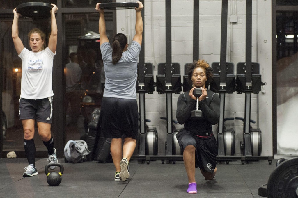 From left: Renegades Sue Quimby, Kimberly Boroyan, and Asia Asanté do conditioning exercises at Crossfit 128 in Wakefield, February 26, 2015. Quarterback Allison Cahill (not pictured) who works as a personal trainer, led the team through conditioning workouts at their first practices(Wicked Local Staff Photo/ Sam Goresh)
