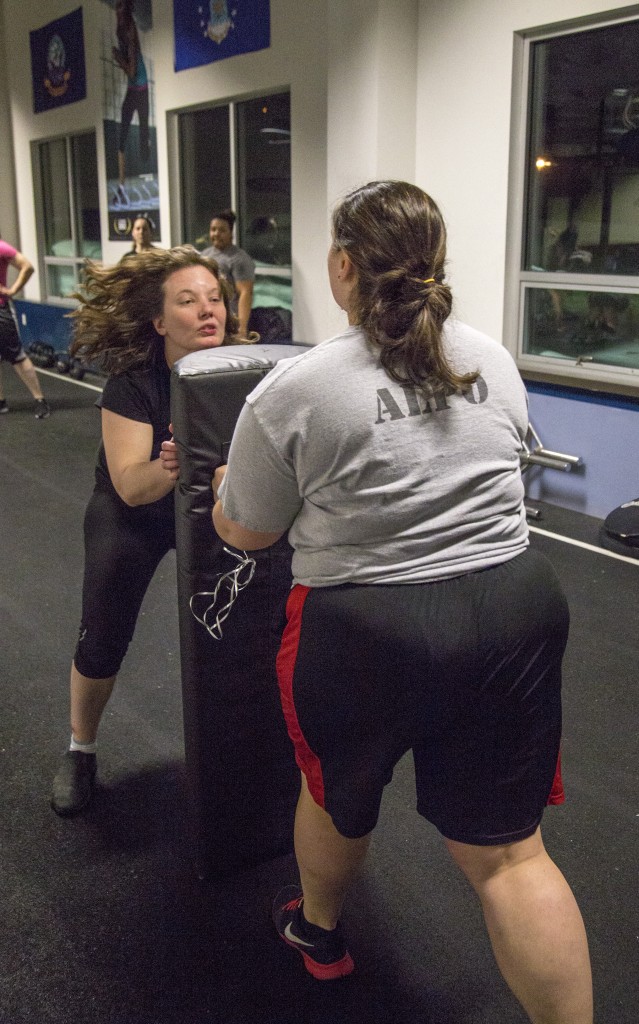 Offensive/defensive linewoman Michelle Breden (left) practices on a blocking dummy held by center Amanda Alpert.