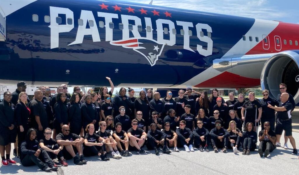 Boston Renegades assemble next to the New England Patriots team plane
