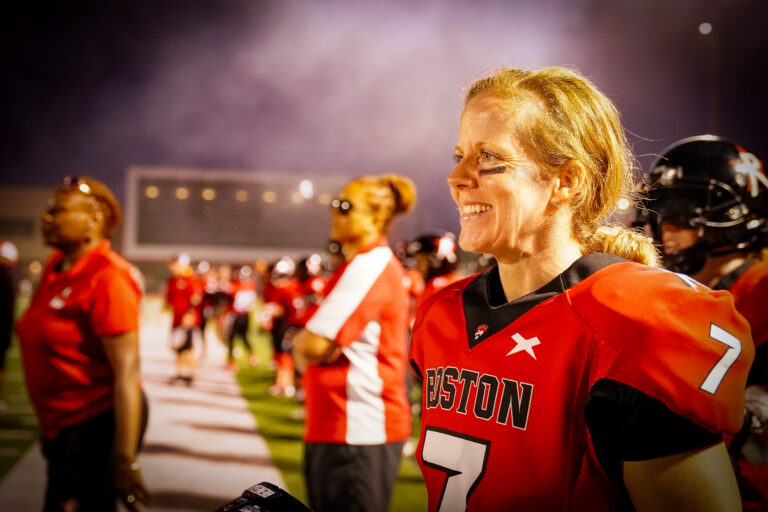 Allison Cahill of the Boston Renegades smiles on the sidelines as the game against the Alabama Fire winds down. Cahill is in her 20th season of pro football.
