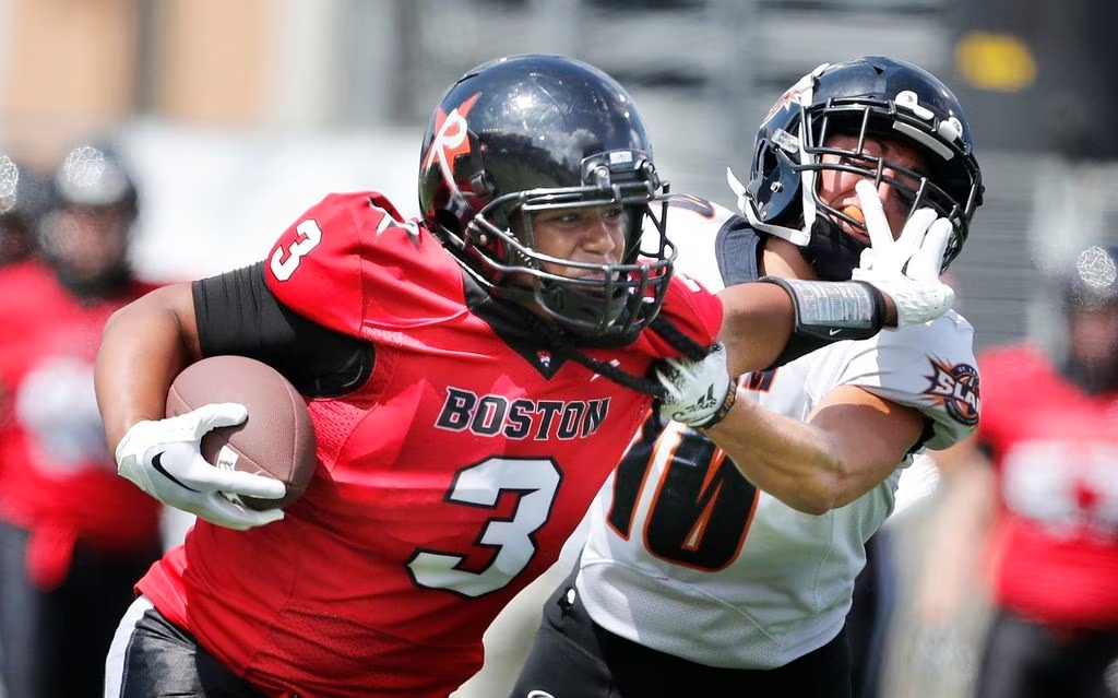 Stephanie Pascual of the Boston Renegades stiff-arms a St. Louis Slam defender on her way into the end zone.