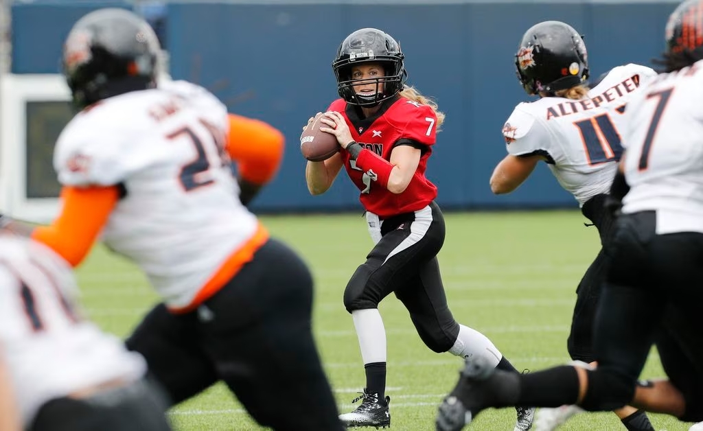 Quarterback Allison Cahill of the Boston Renegades rolls out to throw a pass to teammate Chanté Bonds.